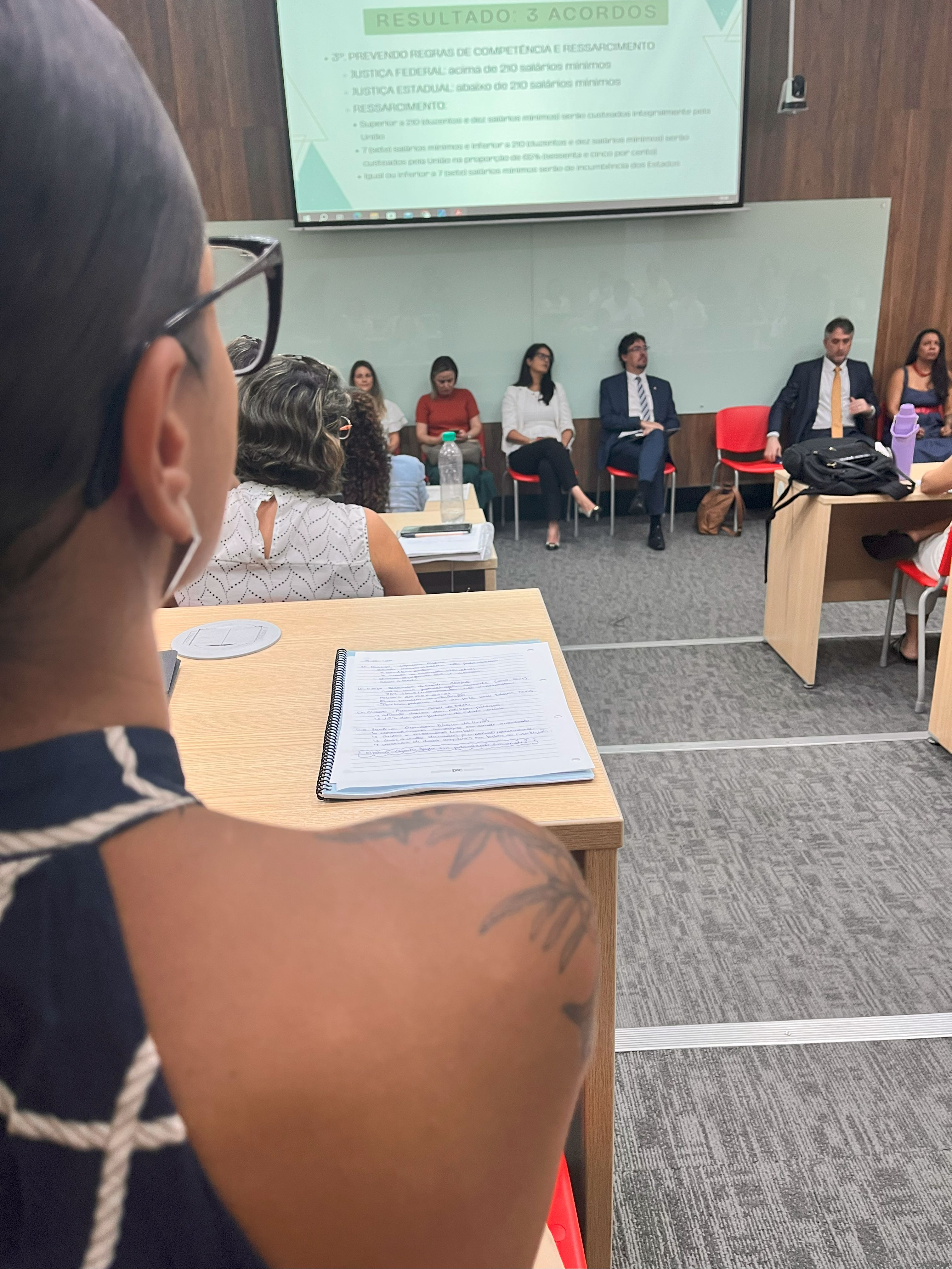 Aluna observando as apresentações, durante o seminário